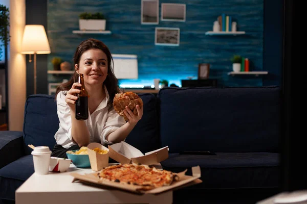 Boldog nő kezében sörösüveg eszik ízletes elvitelre élelmiszer szállítás közben nézi szórakoztató film — Stock Fotó