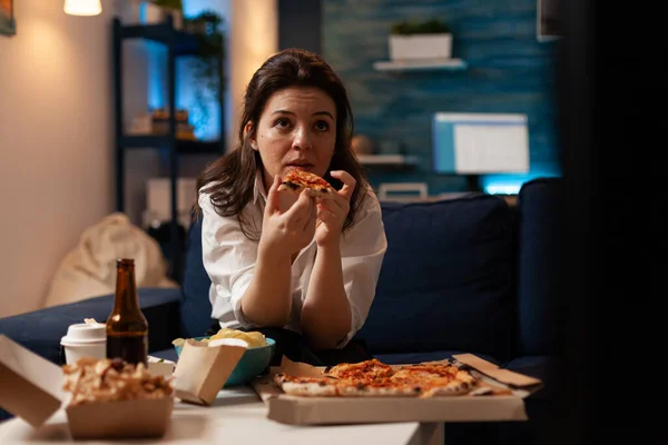 Caucasian female holding delicious pizza slice eating takeaway food delivery