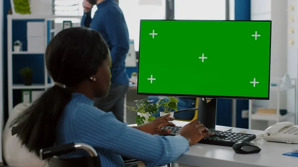 Negro paralizado mujer de negocios sentado en silla de ruedas usando PC con pantalla verde — Foto de Stock