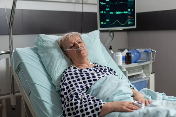 Oudere patiënt na herstelbehandeling in ziekenhuisbed — Stockfoto