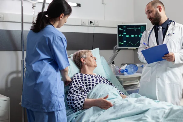 Seniorin liegt im Krankenhausbett und erhält Medikamente durch eine intravenöse Leitung — Stockfoto