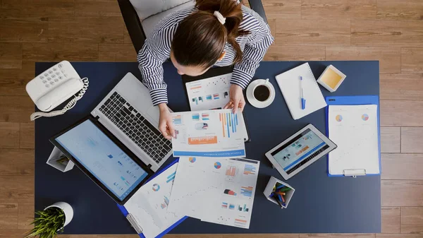 Bovenaanzicht van de zakenvrouw die aan tafel zit om de financiële boekhouding te controleren — Stockfoto