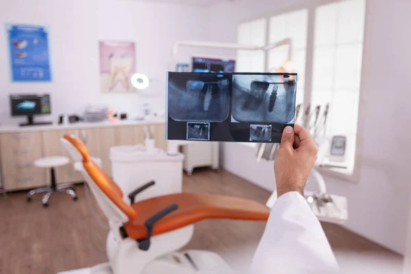 Medico ortodontista in possesso di denti medici mascella radiografia esaminando l'assistenza sanitaria orale — Foto Stock