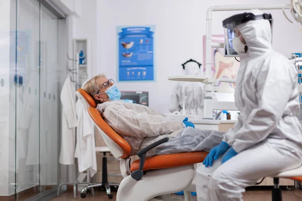 stock image Dentist talking about teeth hygiene wearing hazmat suit