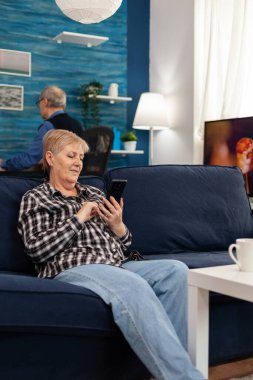 Hapy yaşlı bayan telefonda mesaj atıyor.