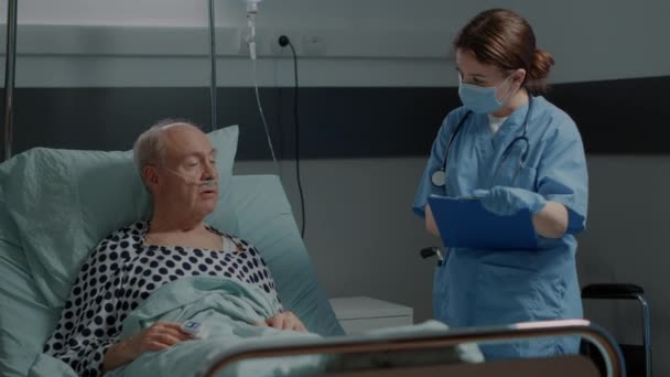 Pielęgniarka szpitalna sprawdza chorego pacjenta — Wideo stockowe