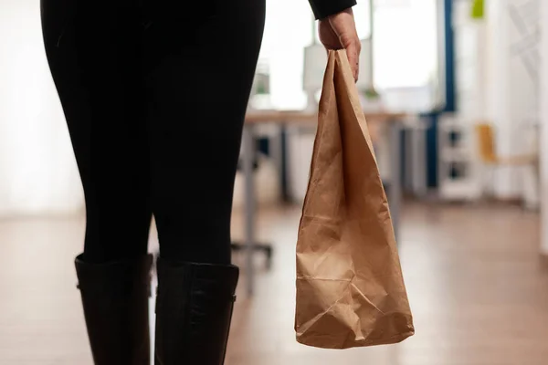 İş kadını elinde paket yemek siparişiyle kağıt torba tutuyor. — Stok fotoğraf