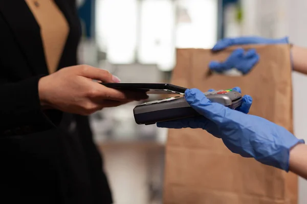 Primo piano della donna d'affari che paga l'ordine di pranzo cibo da asporto con smartphone utilizzando POS — Foto Stock