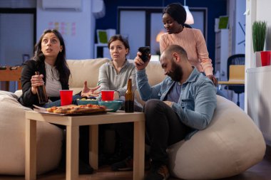 Çeşitli iş arkadaşları televizyonda neşeli oyunlar oynuyor.