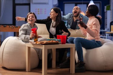 Çok ırklı arkadaşlar ofiste çalıştıktan sonra kutlama yapıyorlar.