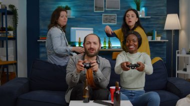 Siyah tenli bir kadın, erkek arkadaşlarına karşı online video oyunları oynuyor.