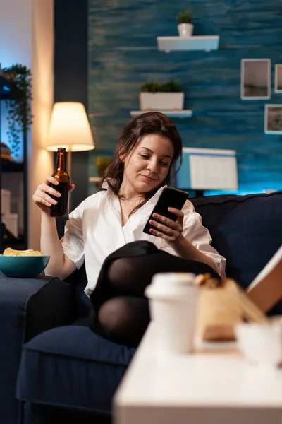Blanke vrouw ontspannen op de bank browsen op sociale media met behulp van smarhphone — Stockfoto