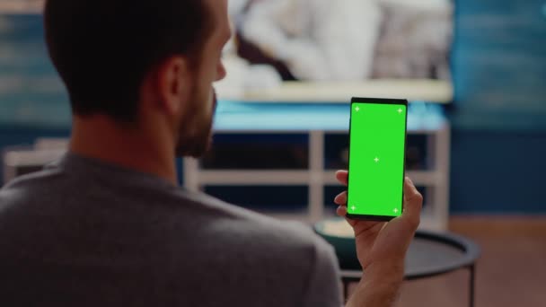 Persona in possesso di telefono cellulare con schermo verde verticalmente — Video Stock