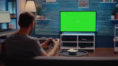 Oturma odasında yeşil ekran modern televizyonu olan adam.