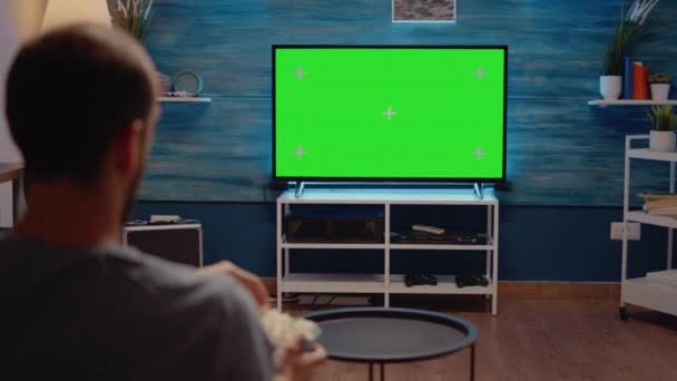 Hombre viendo televisión de pantalla verde en la sala de estar — Vídeo de stock