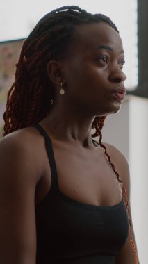 Esmer tenli sporcu kadın spor giyerek evde yoga yapıyor.