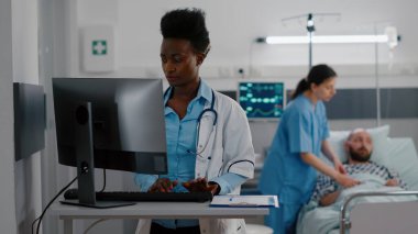Afro-Amerikalı doktorun bilgisayarda tıbbi uzmanlık yazması ön planda