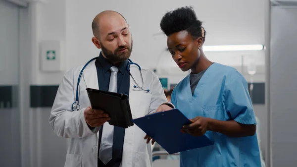 Médecin praticien avec assistant afro-américain analysant le traitement de récupération — Photo