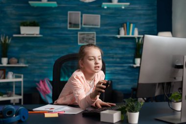 Yorgun ilkokul öğrencisi evden online derse katılıyor.