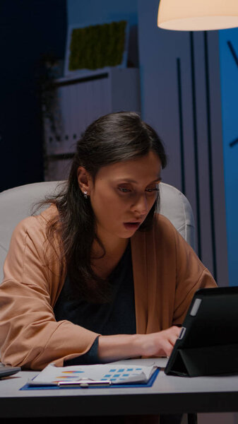 Работоголичная деловая женщина анализирует финансовую графику на планшете