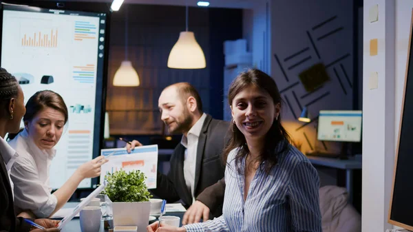 Porträtt av leende affärskvinna tittar in i kameran medan sitter vid skrivbordet i företagets möte kontorsrum — Stockfoto