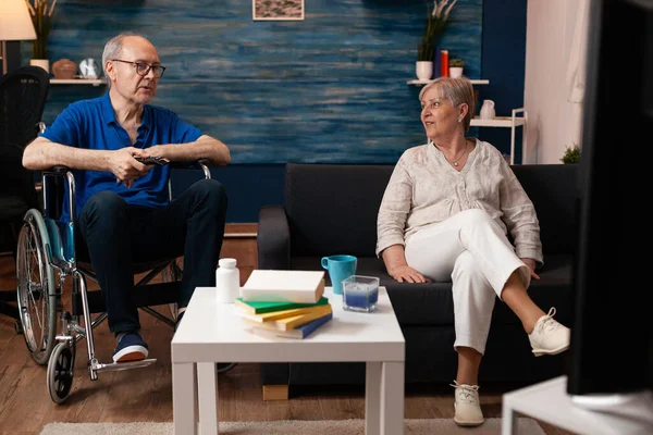 Retired mature people sitting at home smiling — Stock Photo, Image