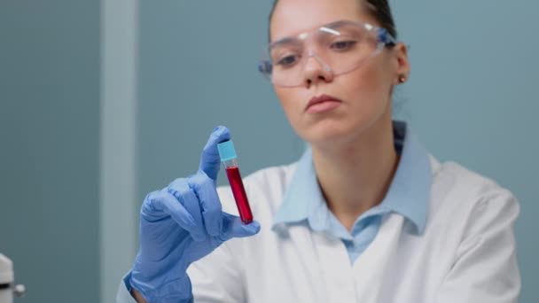 Medico di microbiologia che studia vacutainer con sangue liquido — Video Stock