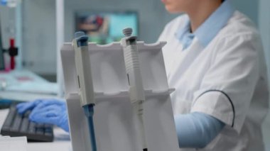 Laboratuvarda mikropipet kullanan biyokimyacıyı kapat.