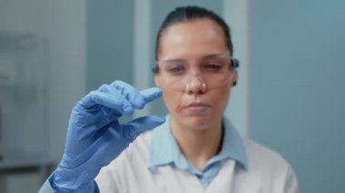 Laboratuvarda kan örneğini analiz eden doktorun portresi.