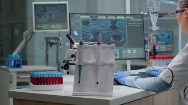 Laboratuvarda kimya teknolojisiyle oturan bilim kadını.