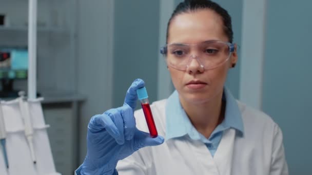유리 청소기를 피로 물고 있는 화학자의 모습 — 비디오