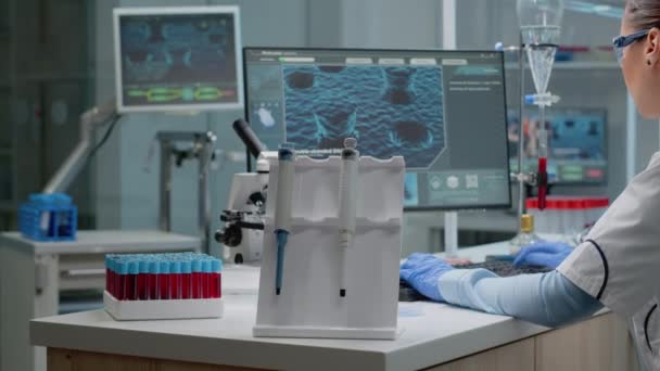 Científica sentada en laboratorio con tecnología química — Vídeos de Stock