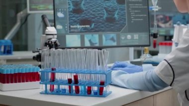 Bilim uzmanı kan örneğiyle test tüpü üzerinde çalışıyor.