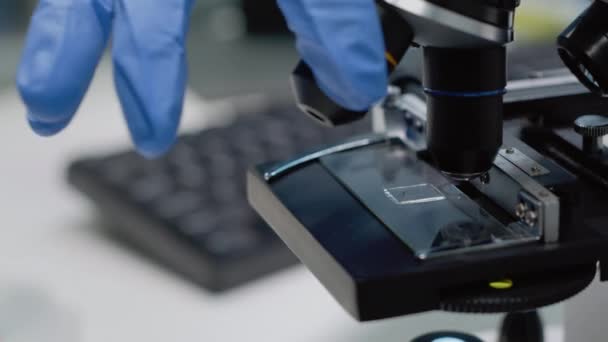 Cierre de la bandeja de vidrio en el microscopio para su examen — Vídeos de Stock
