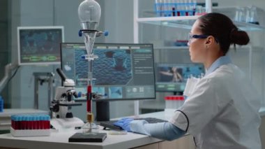 Laboratuvarda animasyon bilgisayarı kullanan kimyager doktor.