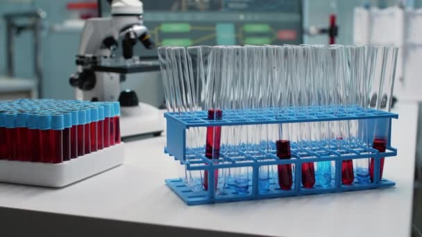 Gros plan des éprouvettes de laboratoire avec du sang sur le bureau — Video