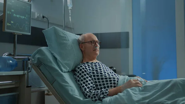 Kranker Patient sitzt mit nasalem Sauerstoffschlauch auf Krankenhausstation — Stockfoto