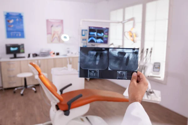 Orthodontist radiologist analyzing teeth jaw radiography working at healthcare treatment — ストック写真