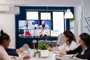 Çalışan işçiler iş arkadaşlarıyla webcam grup konferansı yapıyorlar.