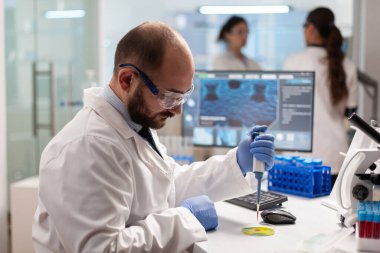 Biyokimya bilimadamı kan örneğini mikro pipetle test ediyor