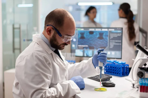 Científico de la salud de Bioquímica analizando muestras de sangre usando micropipeta —  Fotos de Stock