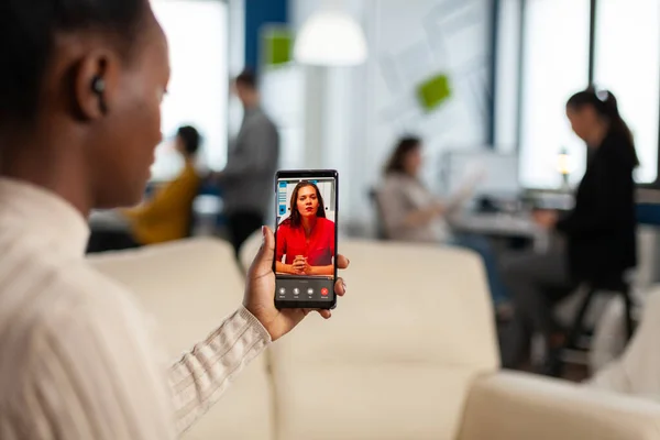 Over de shouder van zwarte werknemer in gesprek met partner op video oproep — Stockfoto