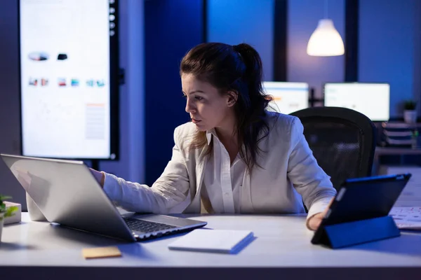 Manager donna utilizzando computer portatile e tablet nello stesso tempo lavorando su rapporti finanziari — Foto Stock