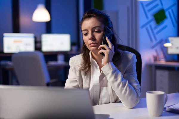 Tired corporate freelancer having conversation on phone while working exhausted for economic statistics — Stock Photo, Image