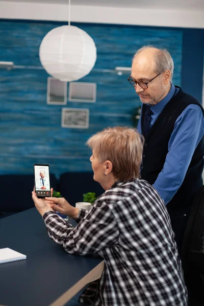 Senior sick man and woman talking with doctor