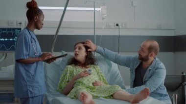 Hamile kadına yardım eden Afrikalı Amerikalı hemşire.