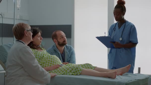 의사와 아프리카 계 미국인 간호사가 아이를 임신 한 여성 상담하는 모습 — 비디오