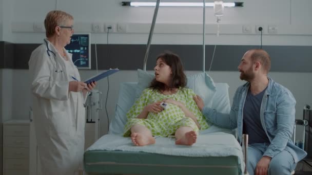 Lekarz oddziału szpitalnego doradztwo kobiety w ciąży w łóżku — Wideo stockowe