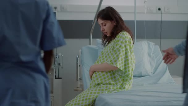 Junger Mann hilft schwangere Frau im Rollstuhl — Stockvideo