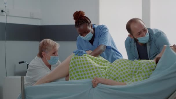 Equipo médico multiétnico que apoya a la mujer dando a luz — Vídeos de Stock